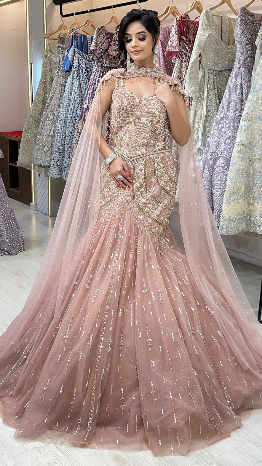 Rose gold mermaid gown with sequins & pearl in net along with cape detailing