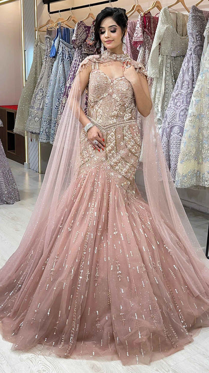Rose gold mermaid gown with sequins & pearl in net along with cape detailing