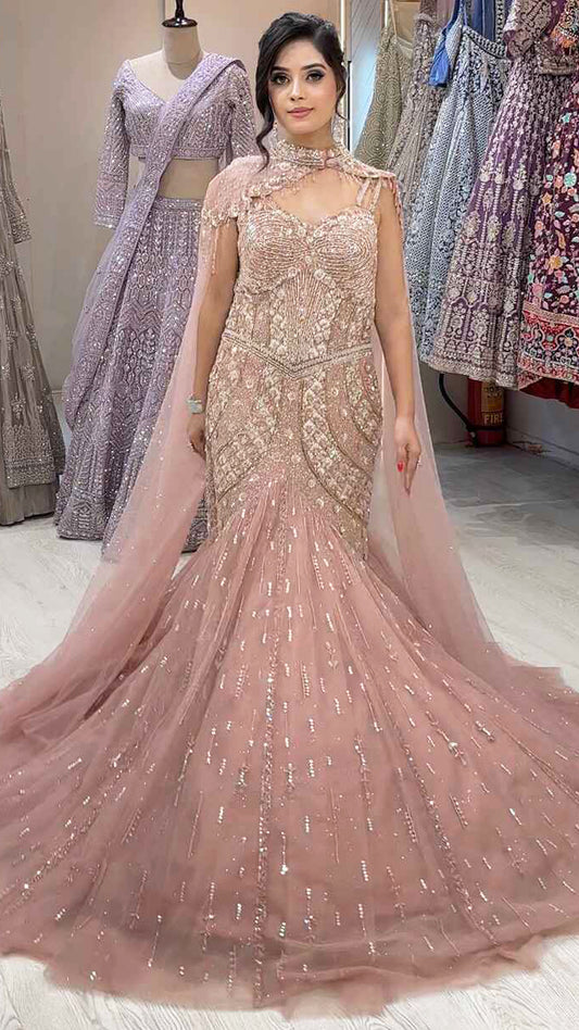 Rose gold mermaid gown with sequins & pearl in net along with cape detailing