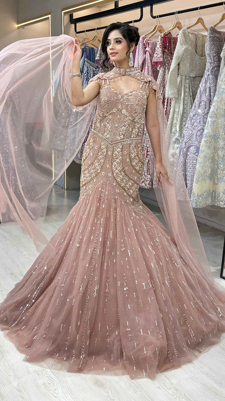 Rose gold mermaid gown with sequins & pearl in net along with cape detailing