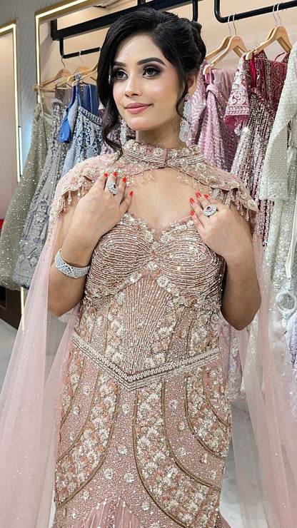 Rose gold mermaid gown with sequins & pearl in net along with cape detailing