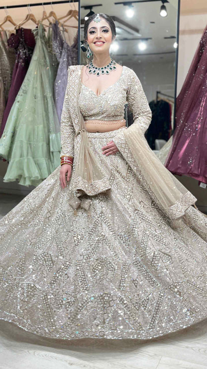 Nude color net bridal lehenga with zarkan & sequins along with heavy dupatta