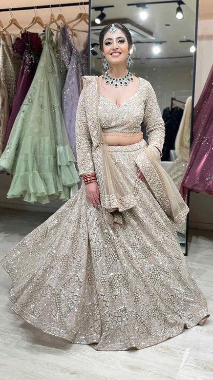 Nude color net bridal lehenga with zarkan & sequins along with heavy dupatta