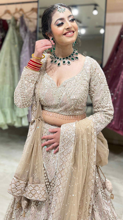 Nude color net bridal lehenga with zarkan & sequins along with heavy dupatta