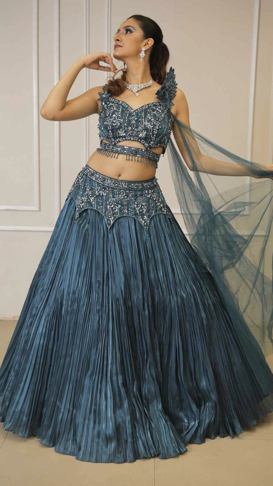 Dark teal lehenga with cutwork blouse on crystal & sequins work with falling sleeves