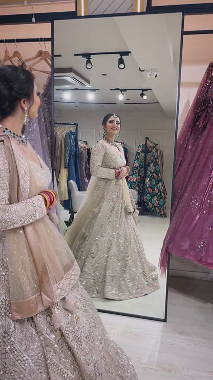 Nude color net bridal lehenga with zarkan & sequins along with heavy dupatta