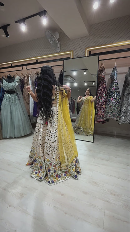 Cream lehenga choli in raw silk with multicolor thread & leather work and contrasting yellow dupatta
