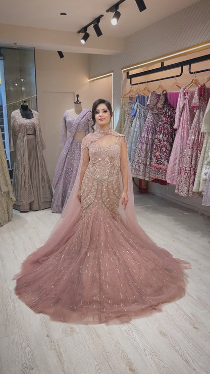 Rose gold mermaid gown with sequins & pearl in net along with cape detailing